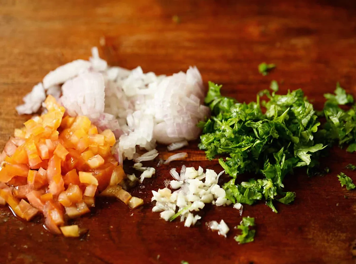 Oignon écrasé, ail et pâte de piment, la première étape de la recette du guacamole