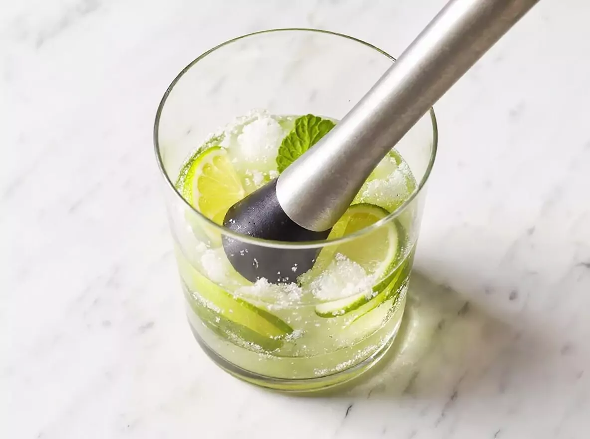 Étape 2 mojito : ajout des quartiers de citron et du sucre blanc dans le verre