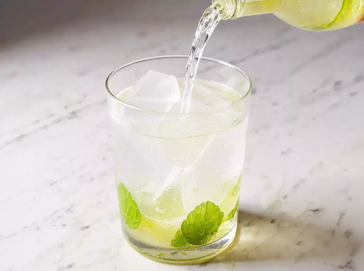 Étape 4 mojito : versement du rhum blanc dans le verre rempli de glaçons