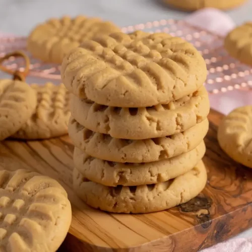 Stack de cookies au beurre de cacahuète moelleux avec marques de fourchette caractéristiques sur une planche en bois